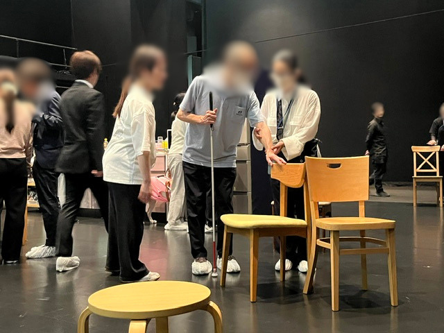 スタッフが後ろの壁に向かって話している写真
